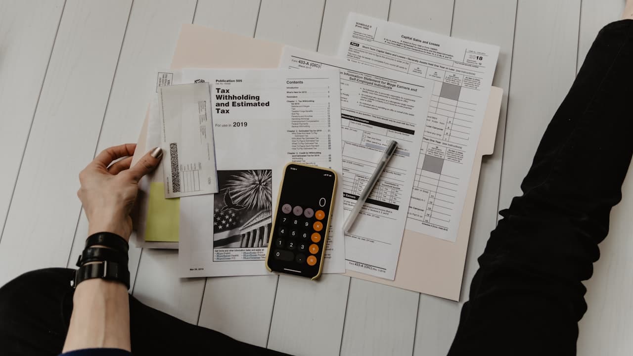 Documents financiers et calculatrice — l'analyse des facteurs qui influencent les primes d'assurance est essentielle pour optimiser les coûts