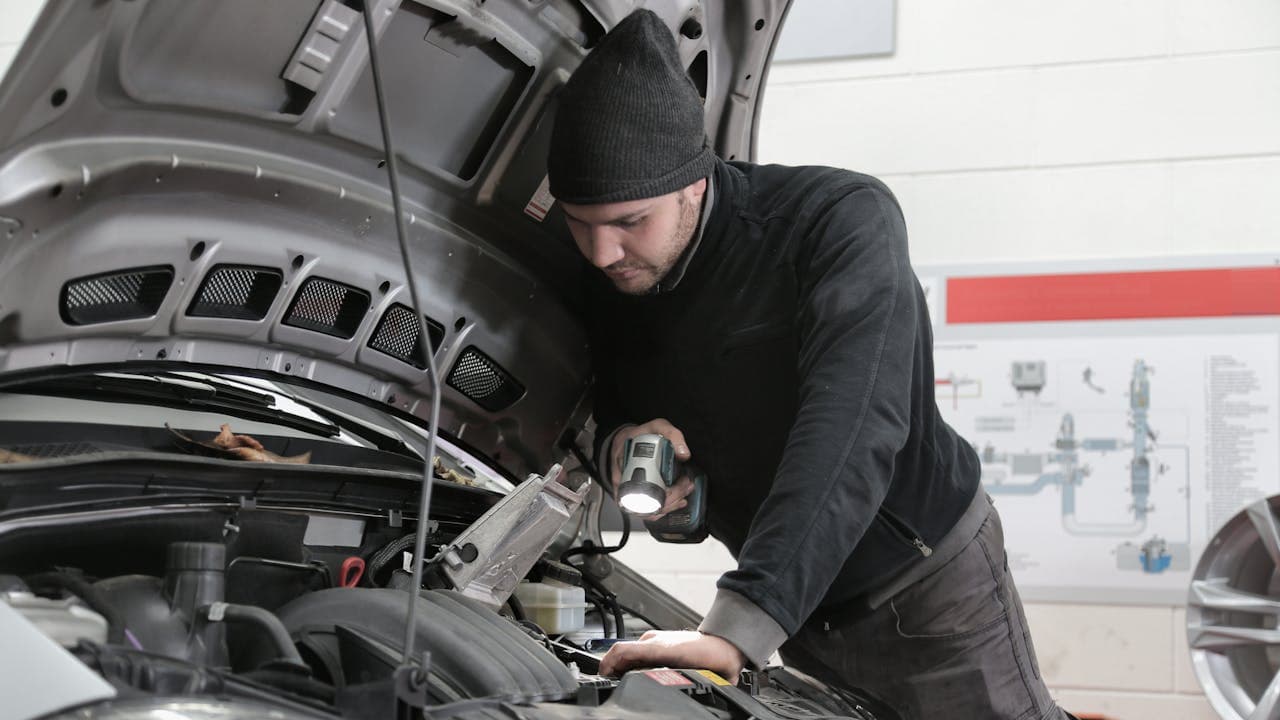 Mécanicien effectuant l'entretien préventif d'un véhicule commercial dans un garage