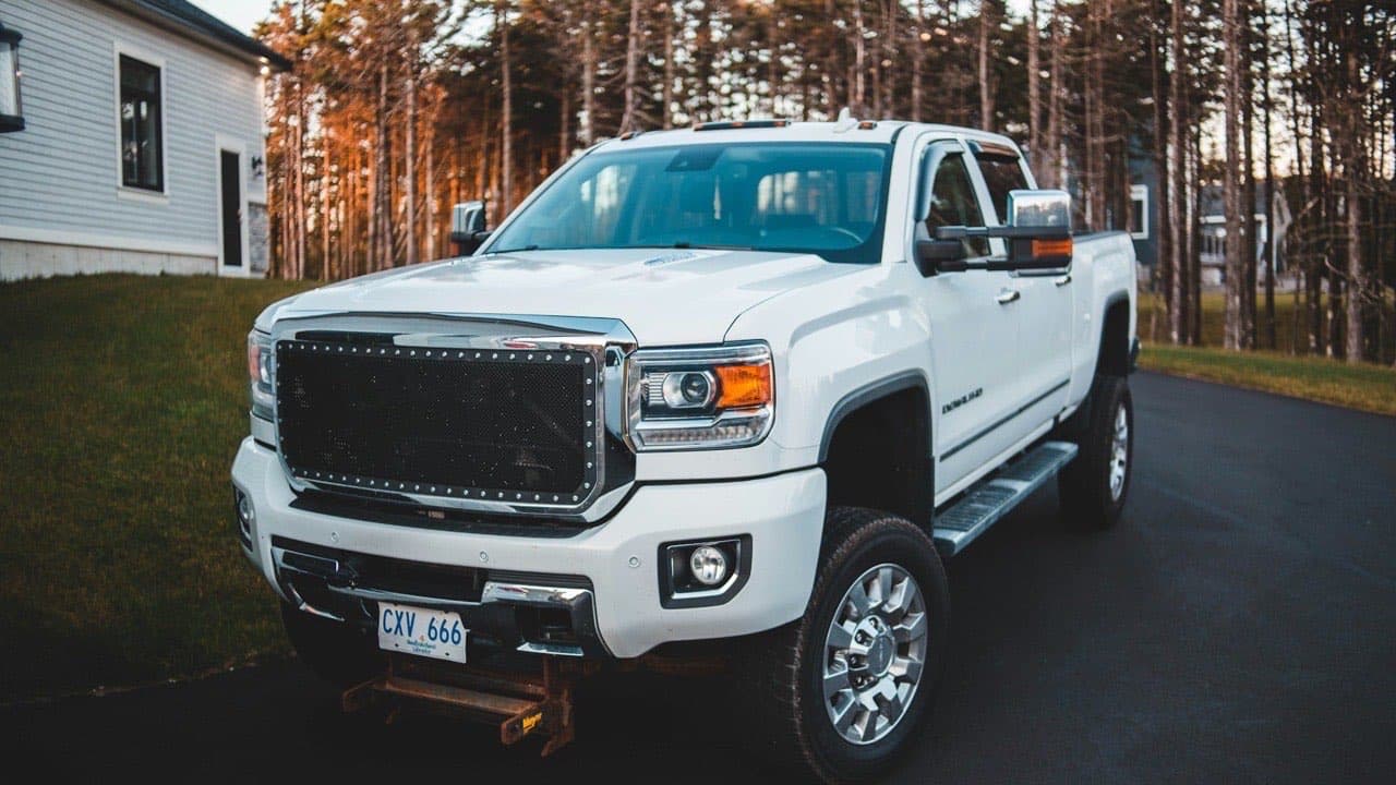Pickup commercial blanc stationné sur un terrain de travail, représentant les véhicules de flotte dont il faut calculer le coût total de possession