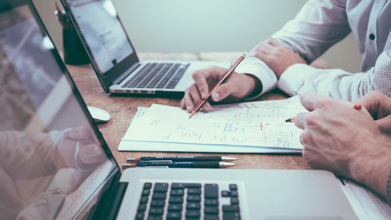 Personne vérifiant des documents administratifs — la consultation du RDPRM est une étape essentielle avant l'achat d'un véhicule commercial